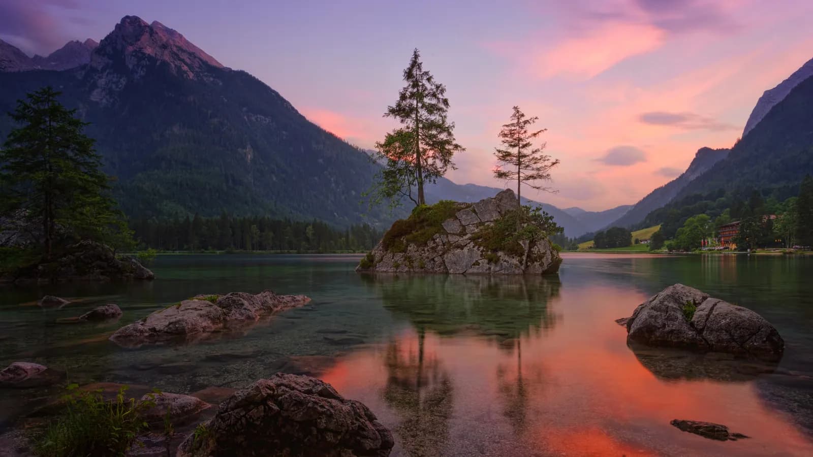 A peaceful lake surrounded by hills at golden hour